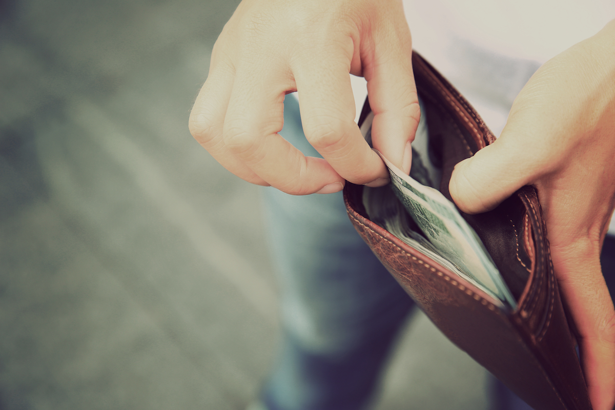Detail shot of hands taking money out of a wallet.