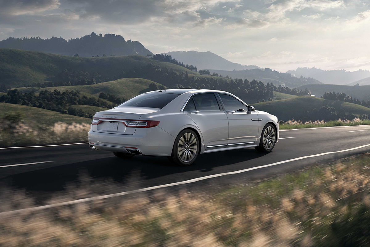 A 2017 Lincoln Continental drives on a scenic highway.