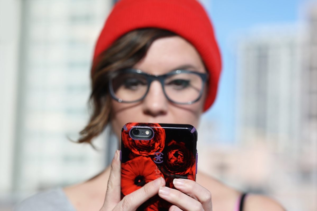 Photographer Heather Comparetto looks at her cell phone at The Penny Hoarder office.