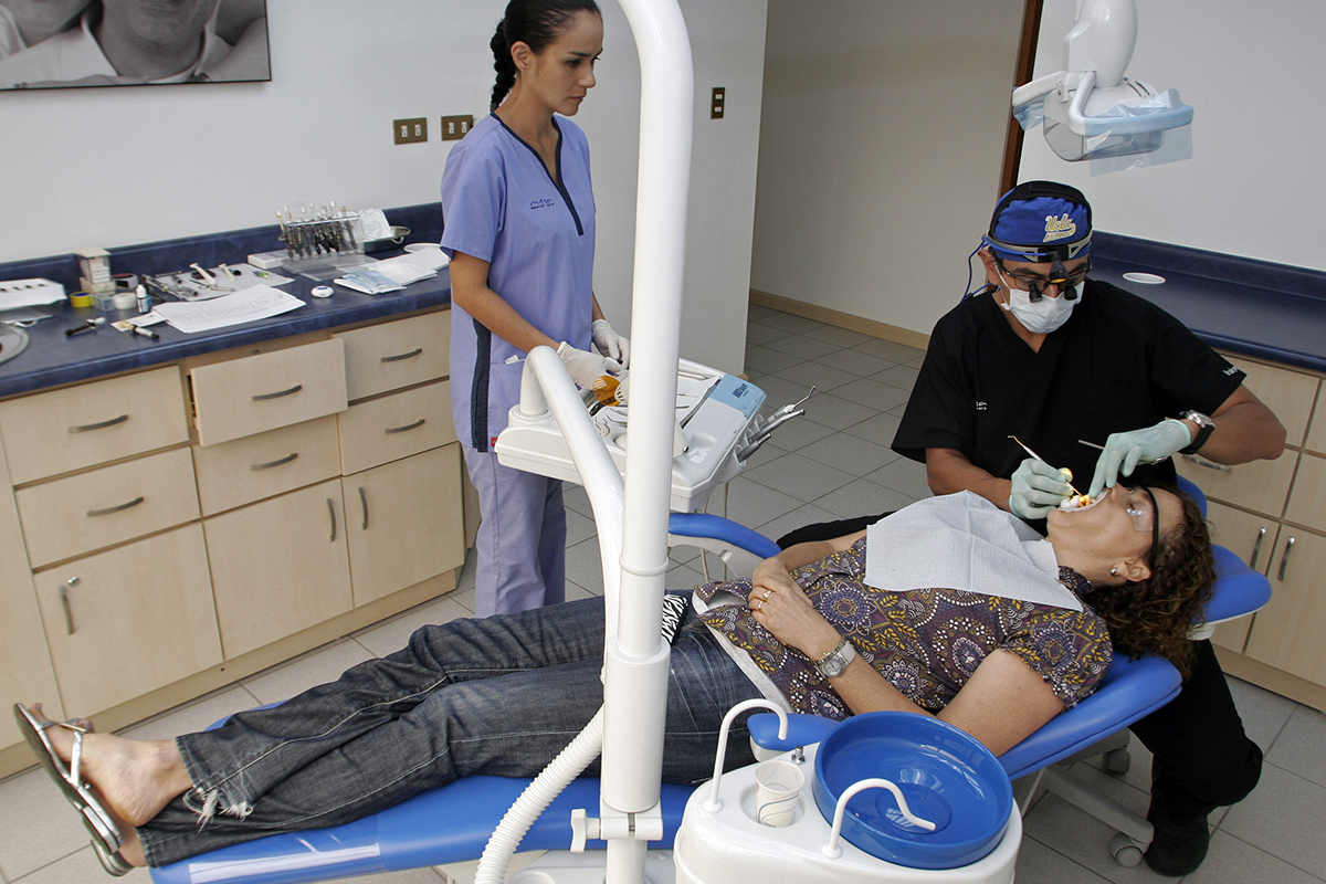 Costa Rican Dentist Alberto Meza, right, applies cosmetic veneers for patient Alison Battle at Meza Dental Care in San Jose, Costa Rica.