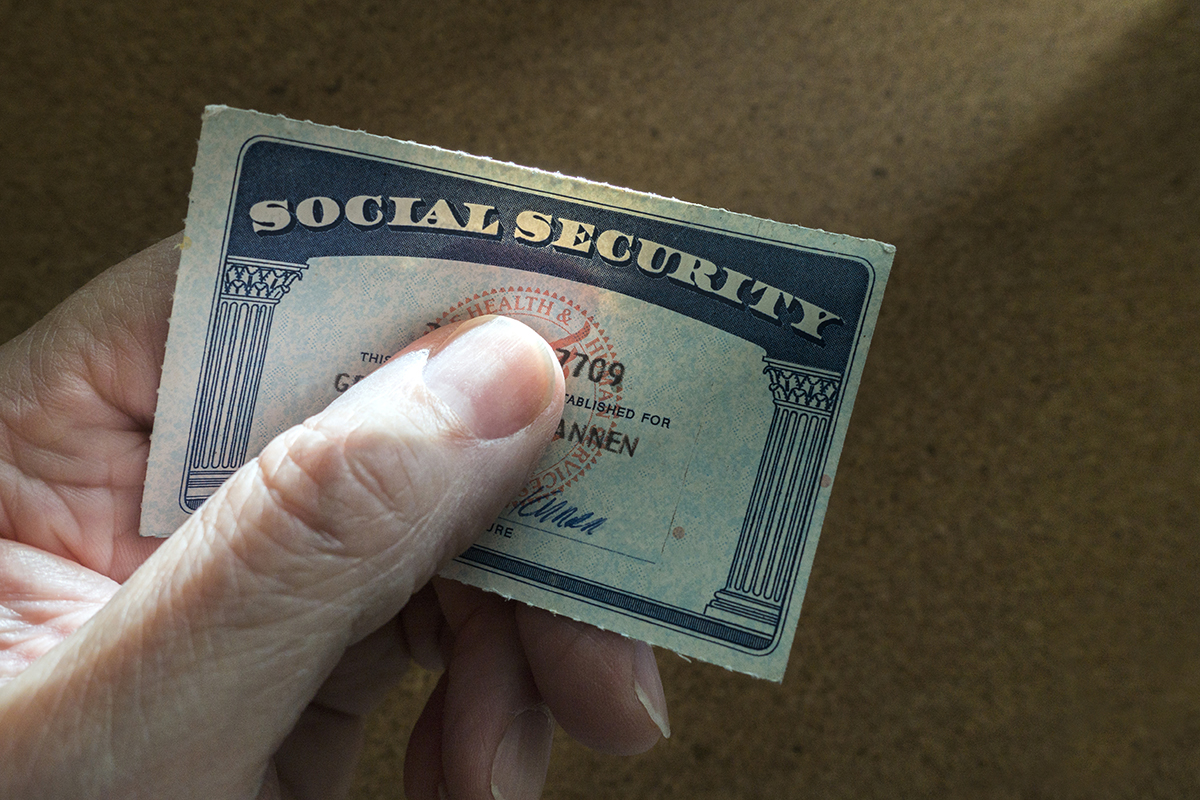 A person holds their social security card.