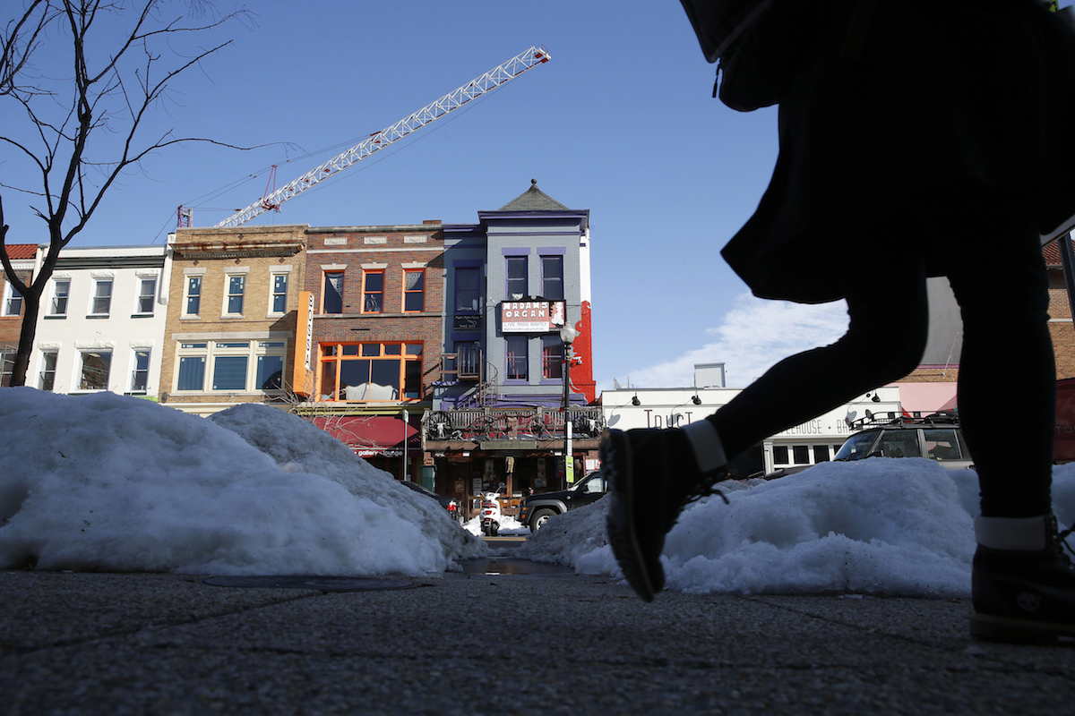 Pedestrians walk past the shops and restaurants on 18th Street NW, on Jan. 27, 2016 in the Adams Morgan area of Washington D.C. Residents of Adams Morgan enjoy a bevy of bars, restaurants, exercise studios and shopping, just steps from their row houses and condo buildings. AP Photo/Alex Brandon