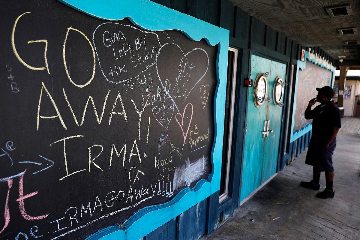 A person reads a sign on a closed restaurant covered with chalkboard messages regarding Hurricane Irma in Flagler Beach, Fla., on Sept. 8, 2017. AP Photo/David Goldman