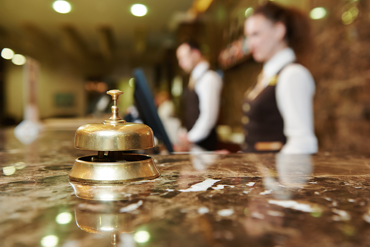 Hotel workers wait to check people into their hotel.