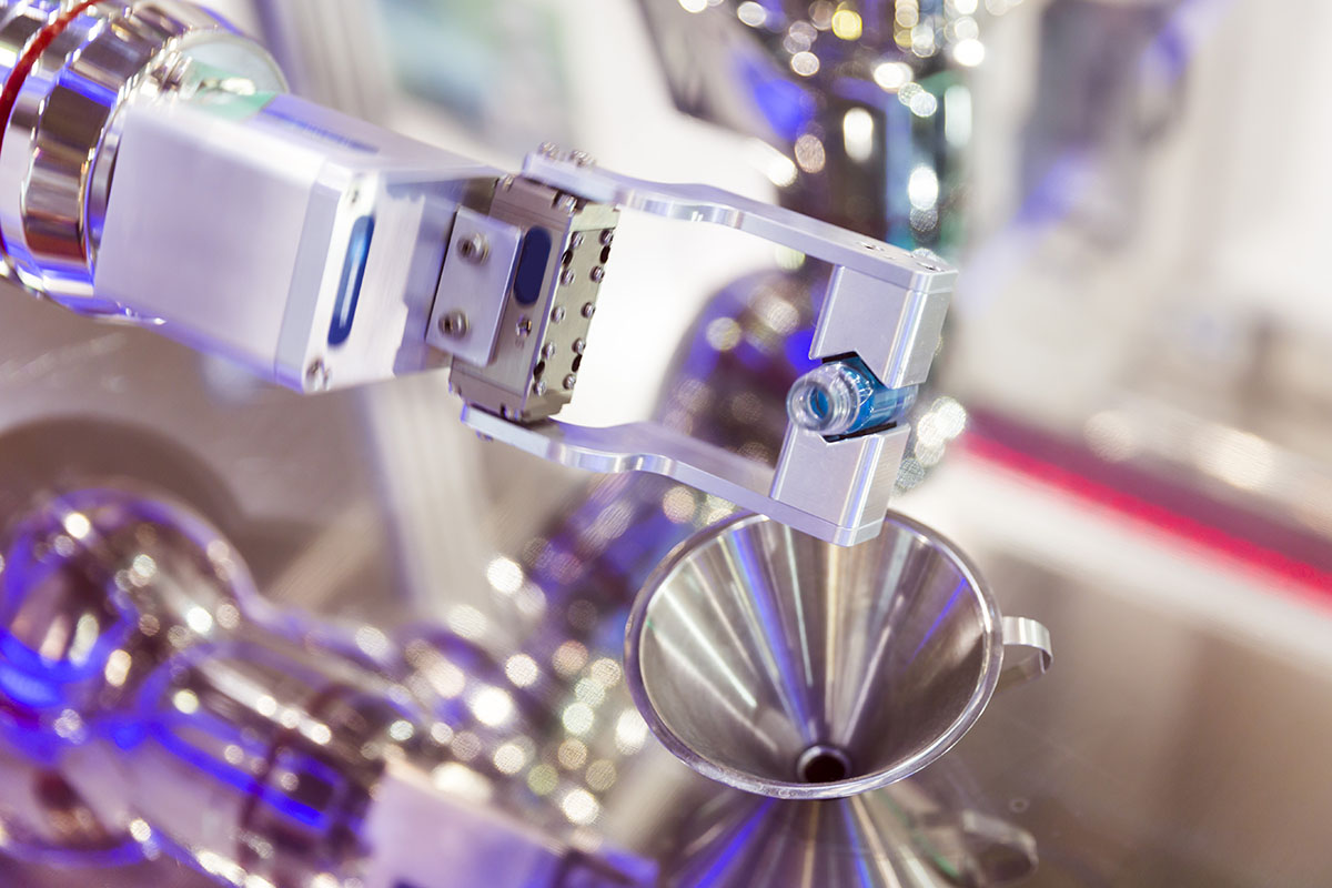 Robotic mechanical arm is pouring chemical tubes full with blue substance in a medical laboratory during a test.