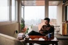 young man working at the table in the bright and beautiful apartmen