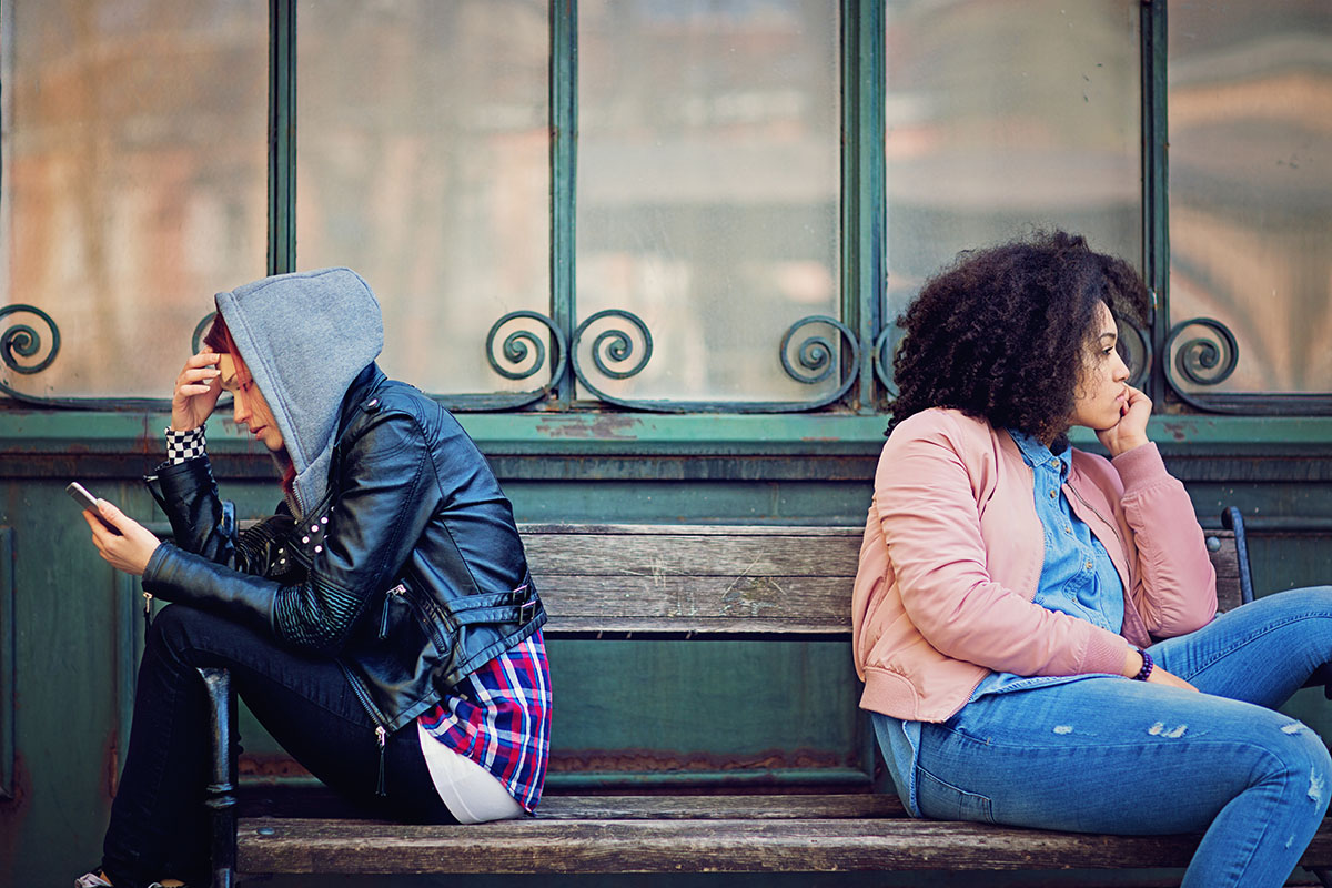friends in conflict are sitting on the bench and sulking