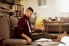 A man works on paying his bills at home.