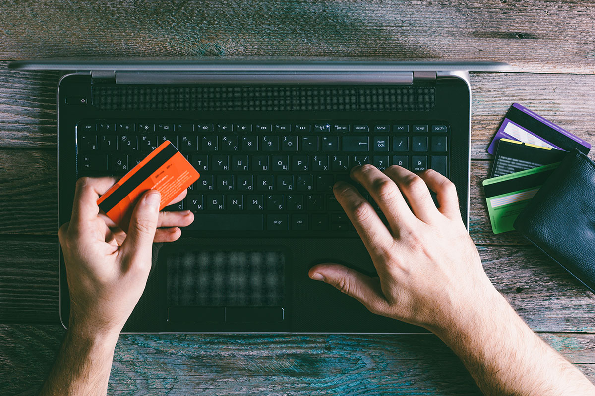 A person puts in their credit card information to purchase something on the computer.