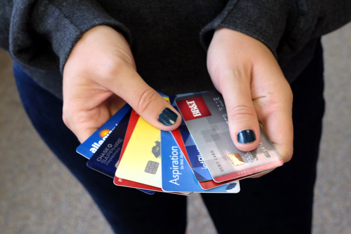 A woman holds several credit cards