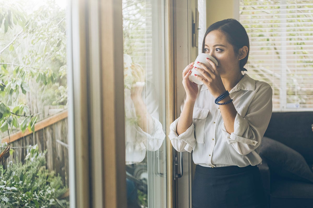 woman looking out window at home