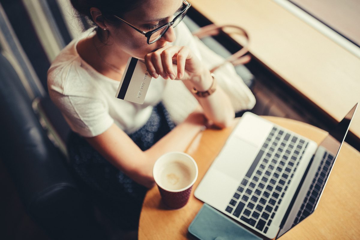 woman holding a credit card looking at laptop