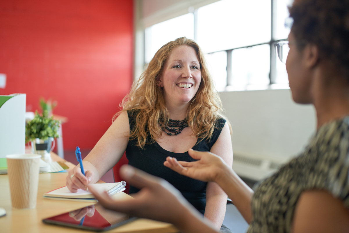 two women talking in an office environment