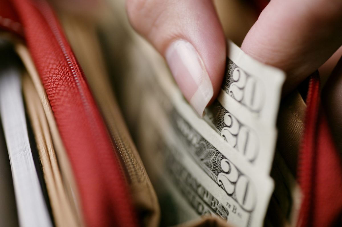 Woman's hand taking money out of wallet.