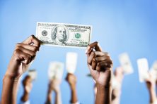 hands hold up US $100 bill