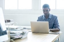 man working on a laptop computer in home office