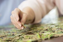 Close up of woman's hand putting together puzzle