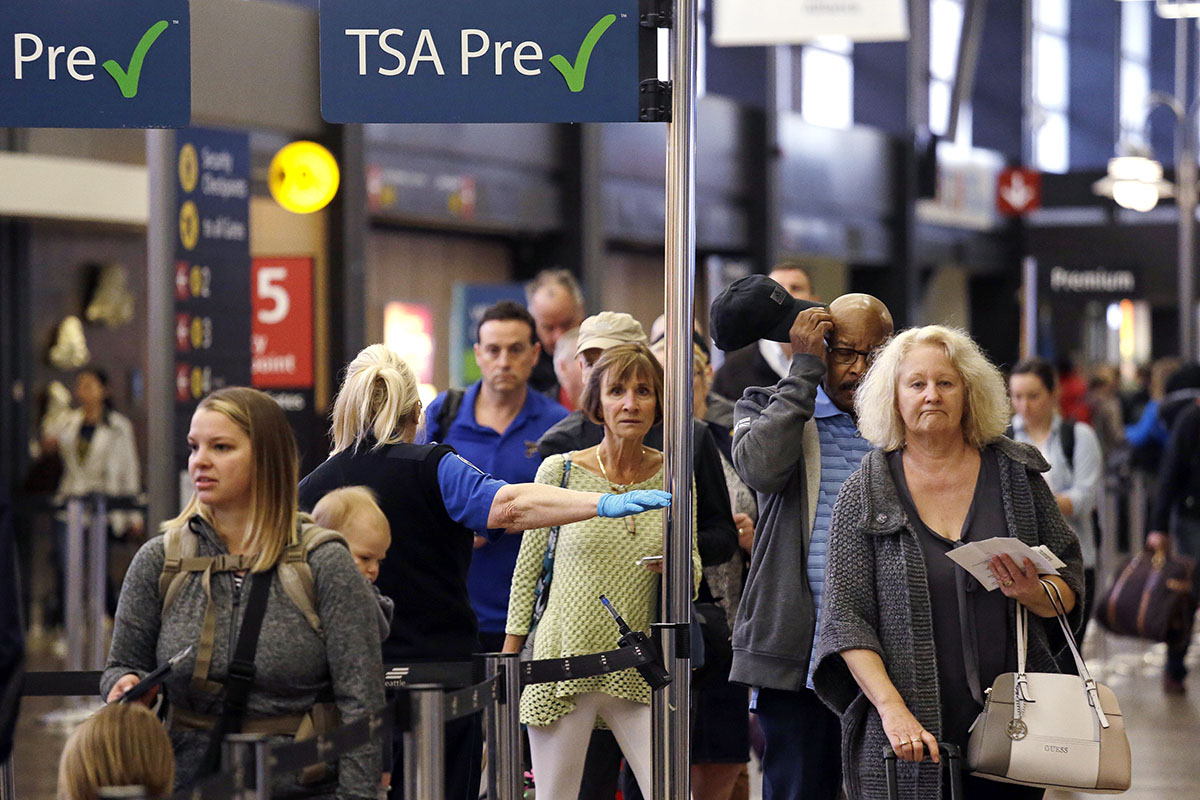 Passengers at a TSA pre-check line are directed to go through a security checkpoint