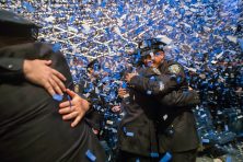 Two police officers hug during their graduation in New York City.