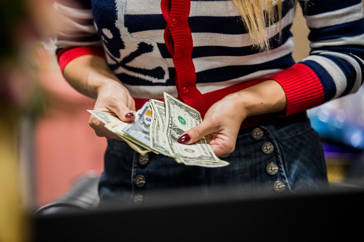 Irina Bilka counts tips and factors bills, Tampa Fla, on November 3th, 2017.