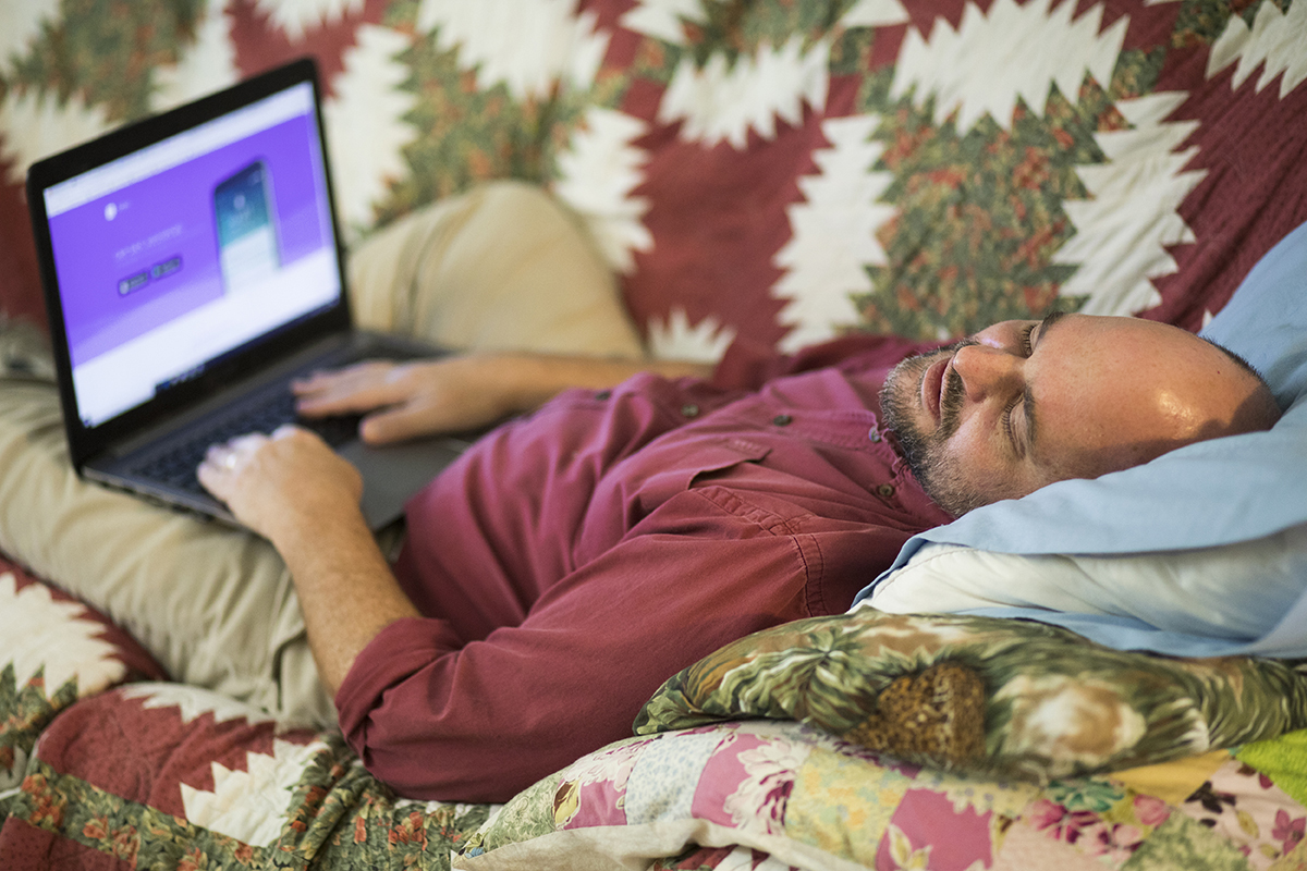 A man takes a nap on his couch while working from home.