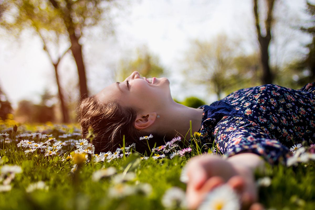 teenage girl laying in the grass