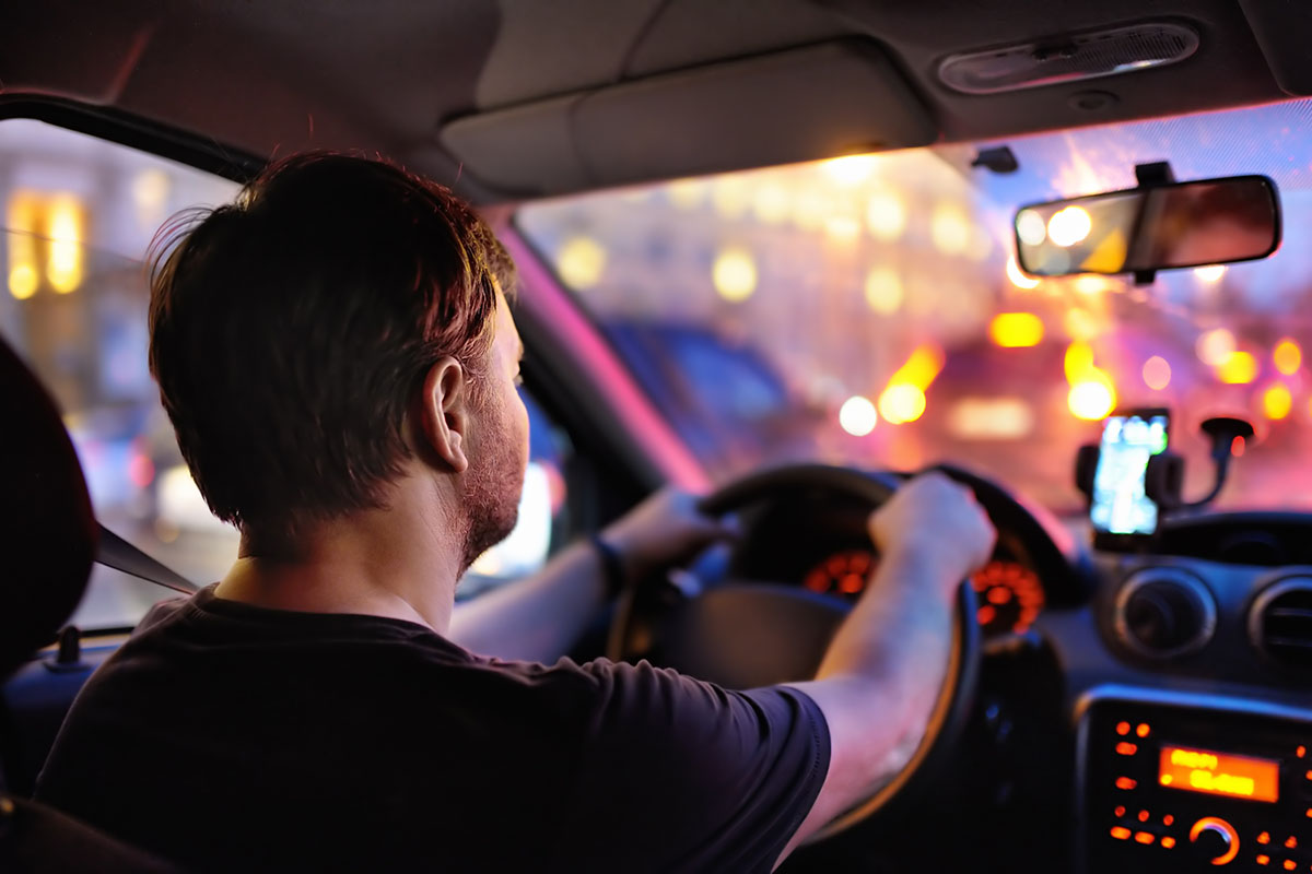 Male driver ride a car during evening traffic jam.