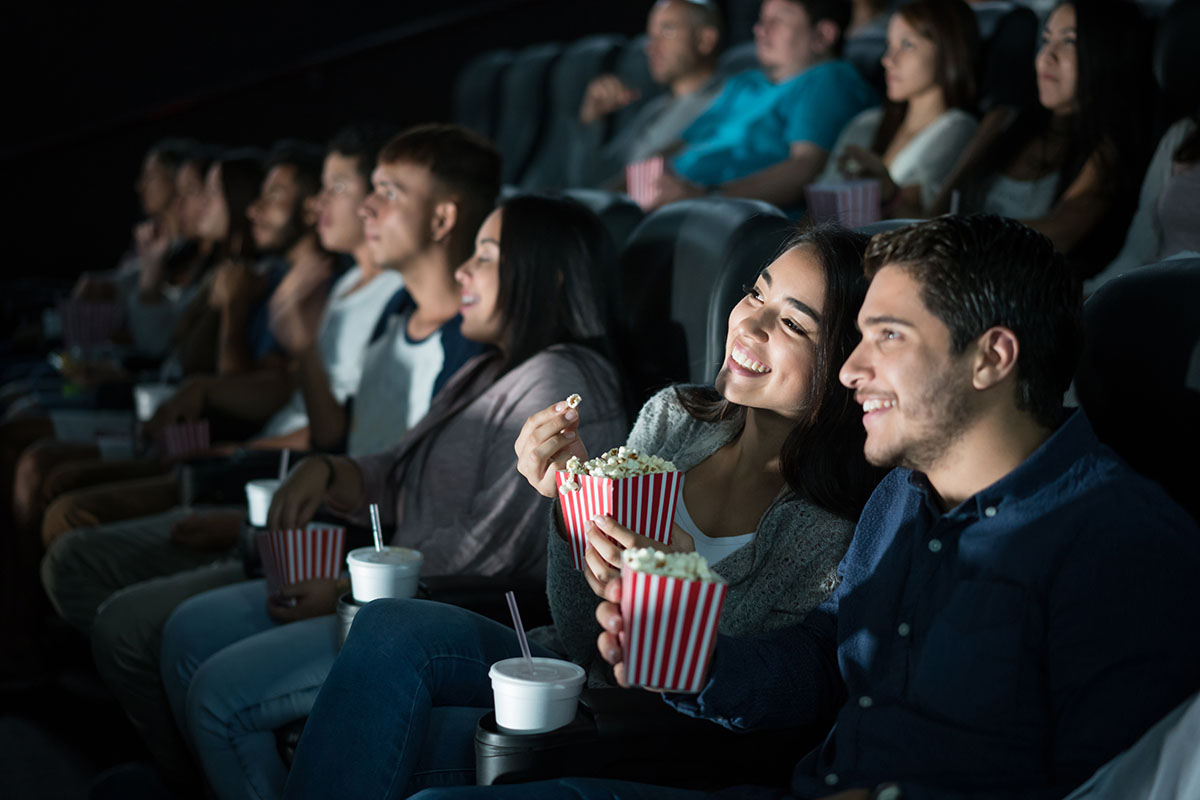 couple at the movies eating popcorn and watching a film