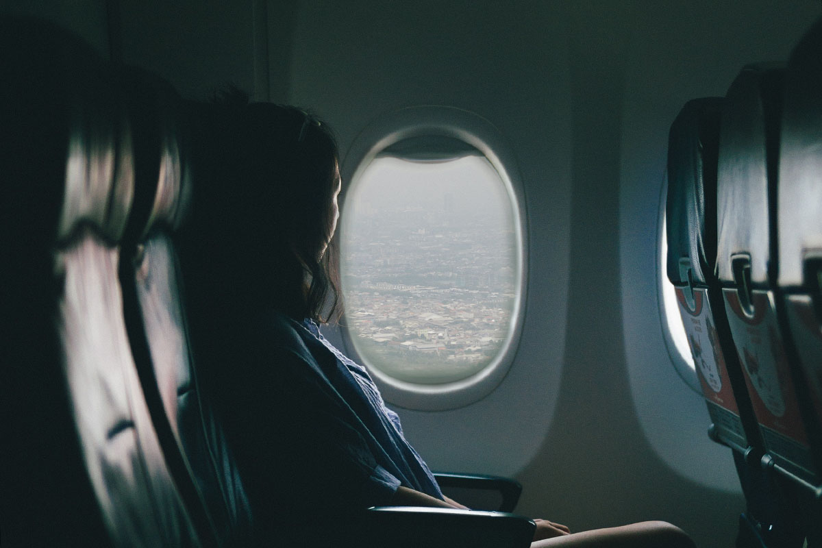 woman looking out of window on airplane