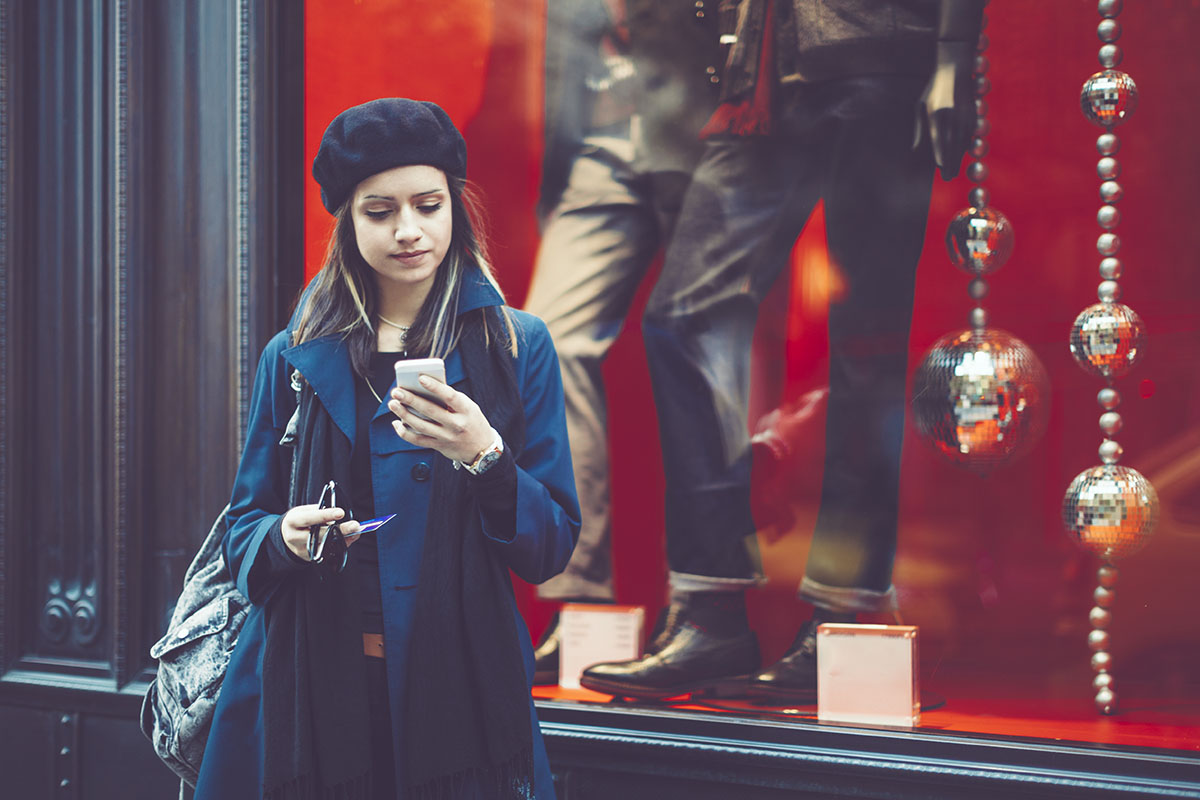 woman out christmas shopping alone looking at her phone