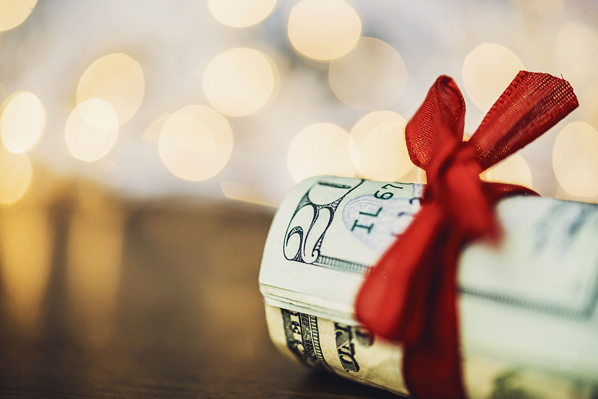 Wad of American currency tied with red ribbon