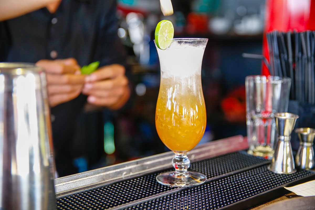 Close up male bartender preparing long island iced tea