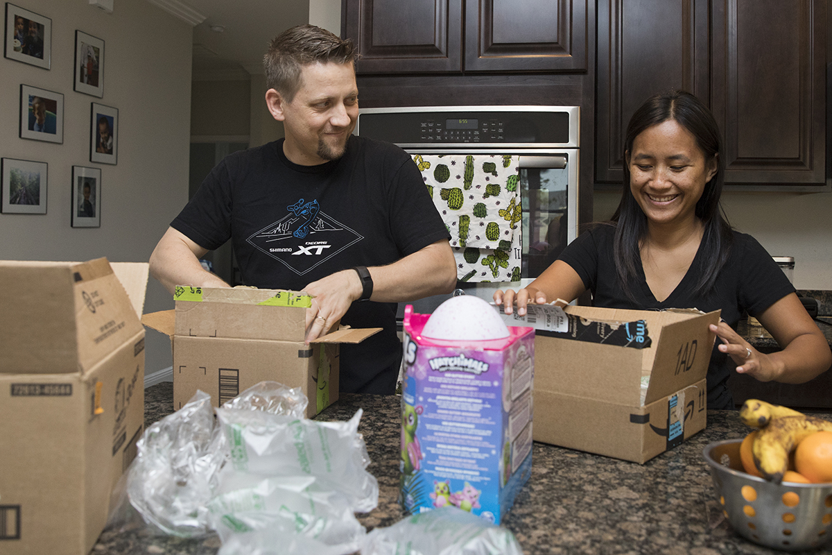 A married couple boxes up items they sold online.