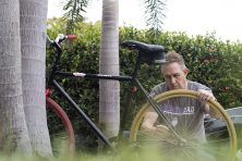 A middle-aged man touches up a bicycle to sell as his side-gig.