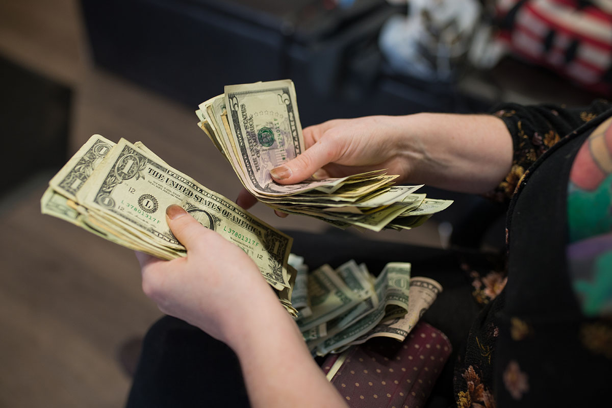 cash being counted in woman's hands