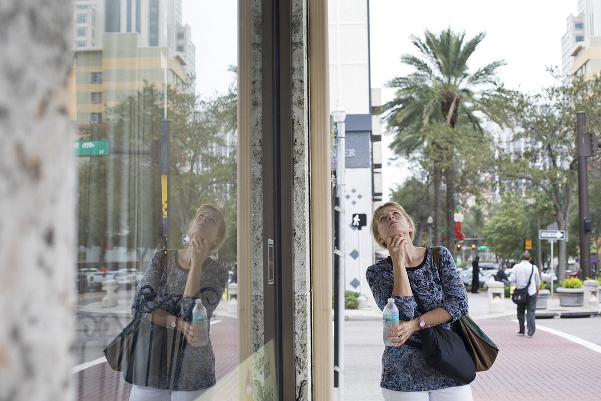 A woman looks at the building structure of a building in downtown St. Petersburg, Fla.