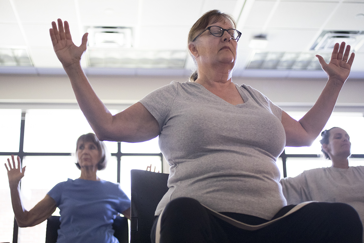 Older women participate in a chair yoga class at a library in St. Petersburg, Fla.