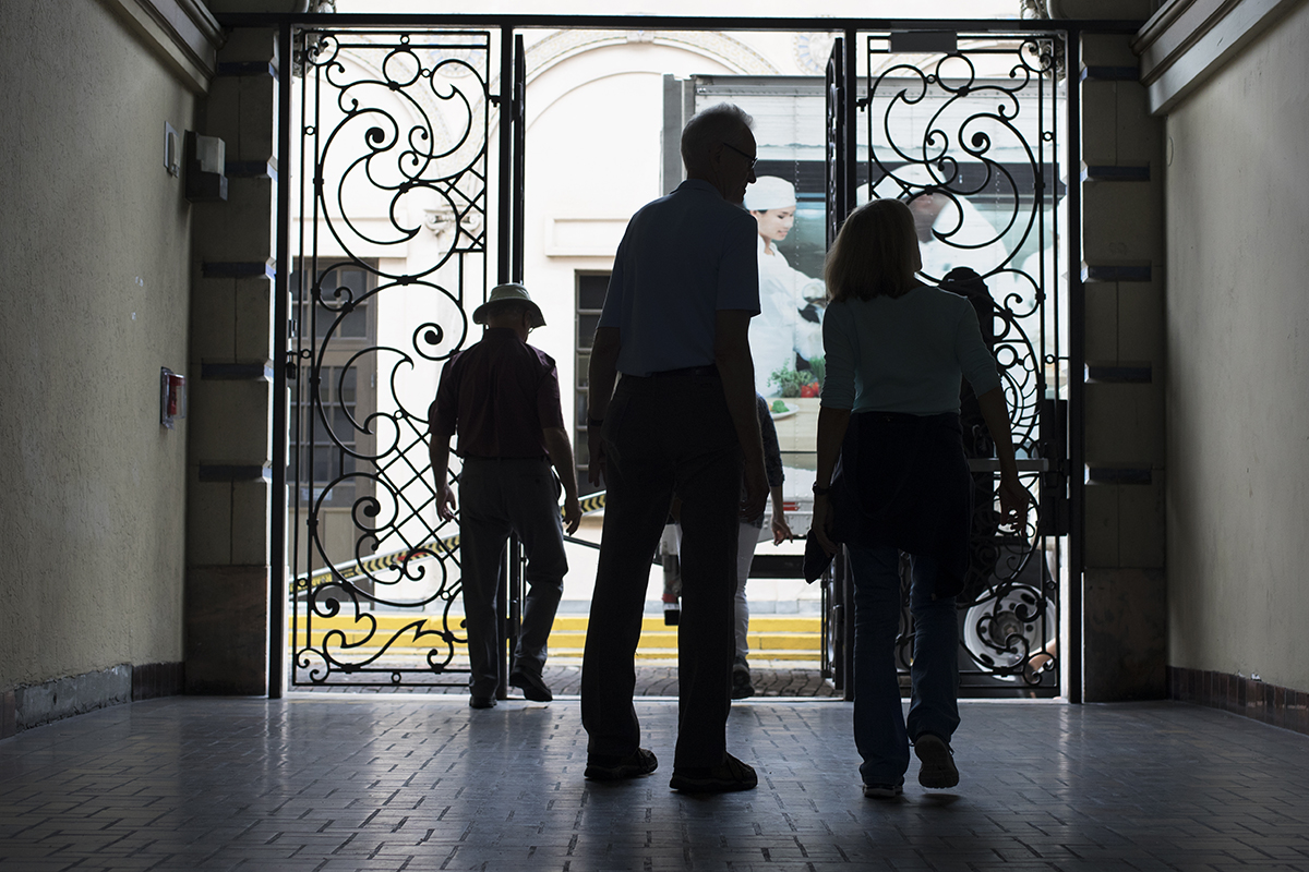 A tour group becomes a silhouette as they walk through an enclosed walkway in downtown St. Petersburg.