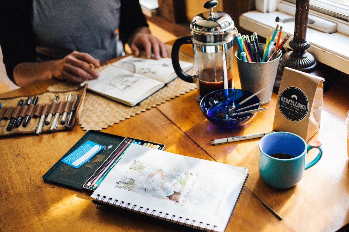 an artist with artist tools spread out on the table