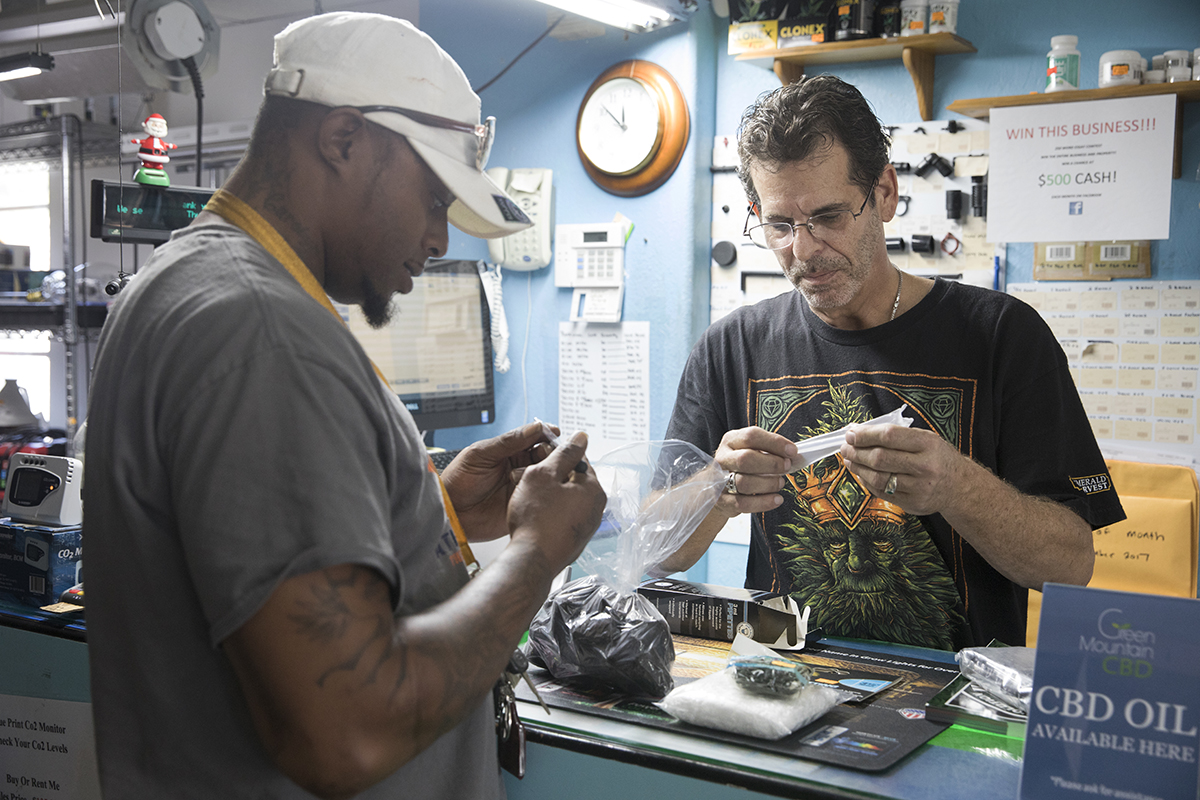 Charles Dorsey looks at a product to buy from Allan Bednar, owner of Simply Hydroponics and Organics in Largo, Fla., on Dec. 6, 2017.