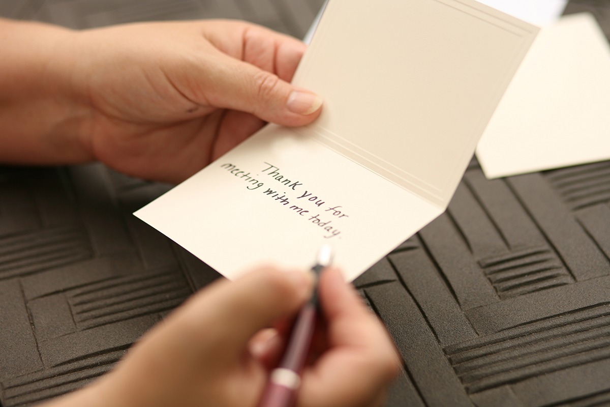 A person writes a thank you note after going on a job interview.