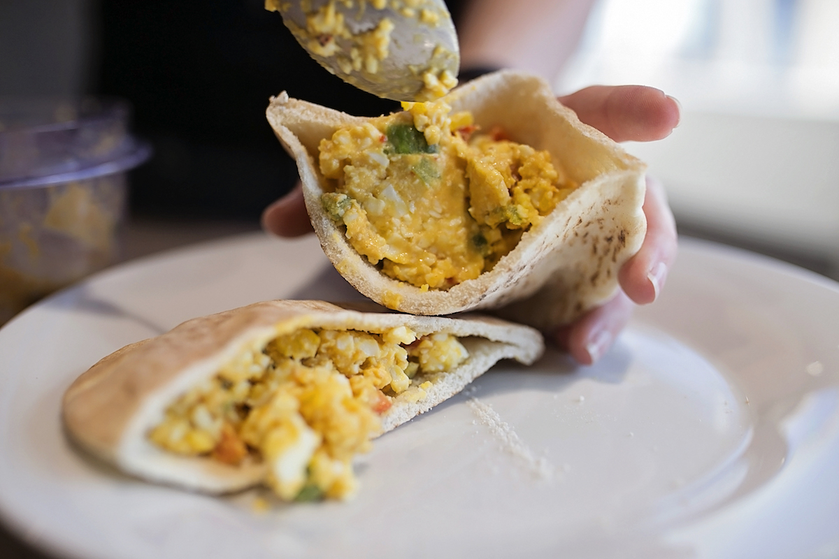 a pita sandwich being assembled