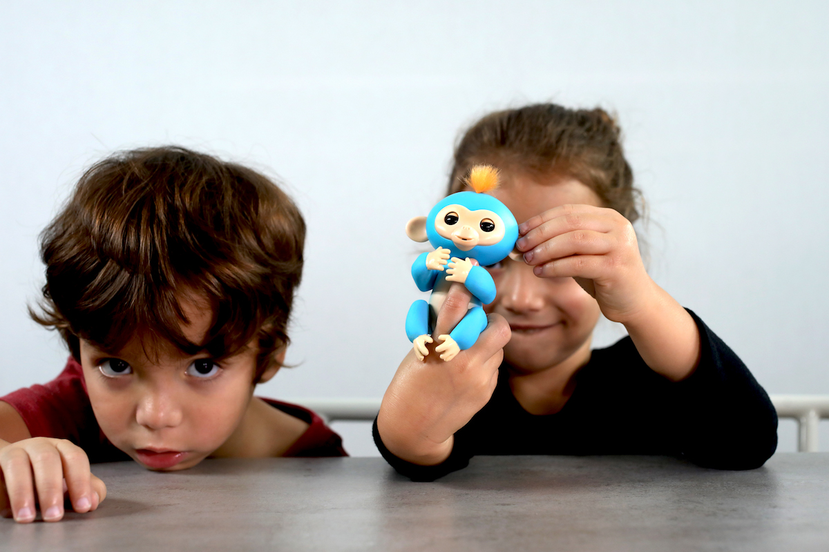 two kids playing with the finglerling toy