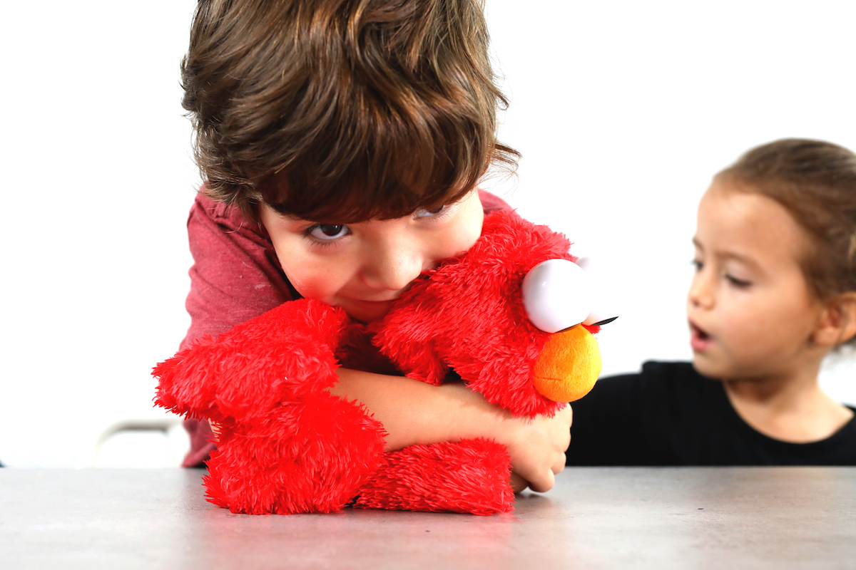 a boy hugging tickle me elmo