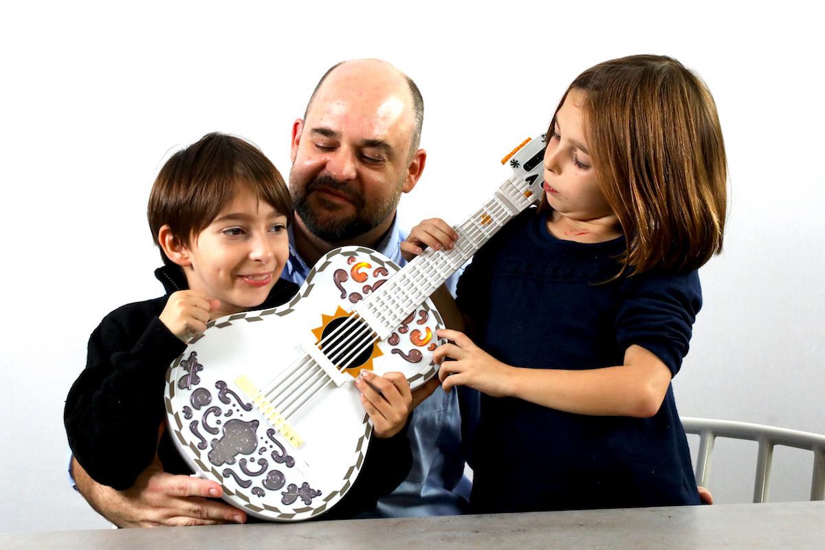 two girls playing with the coco guitar