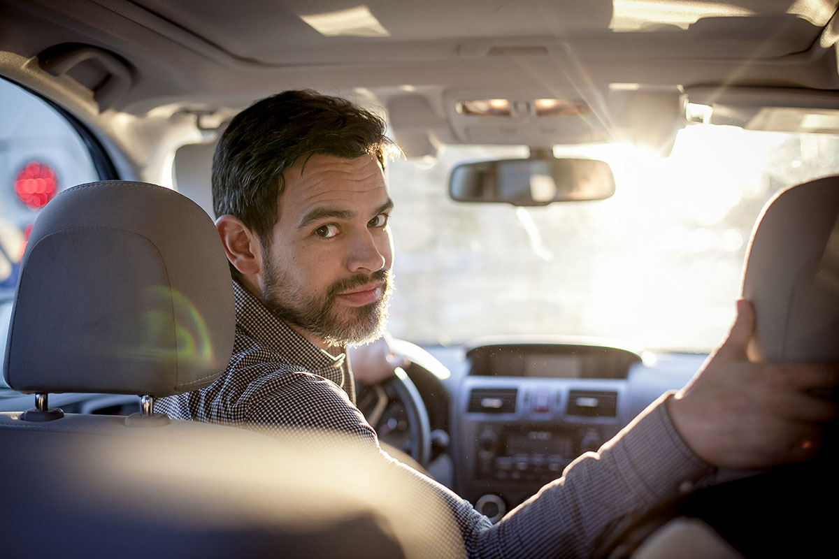 lyft driver anthony ponce in front seat of his vehicle