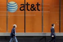 People pass an AT&T store on New York's Madison Avenue.