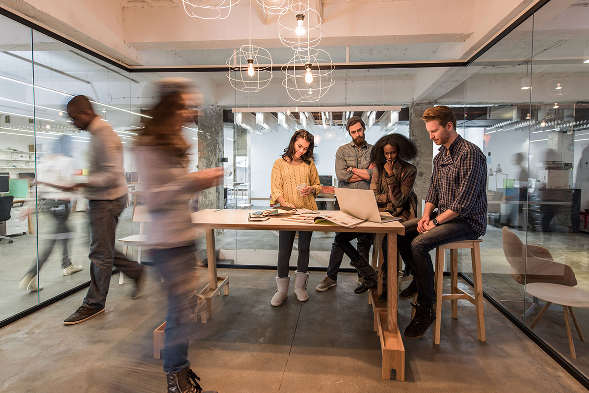 people standing in the office and working together on computer. Blurred motion.