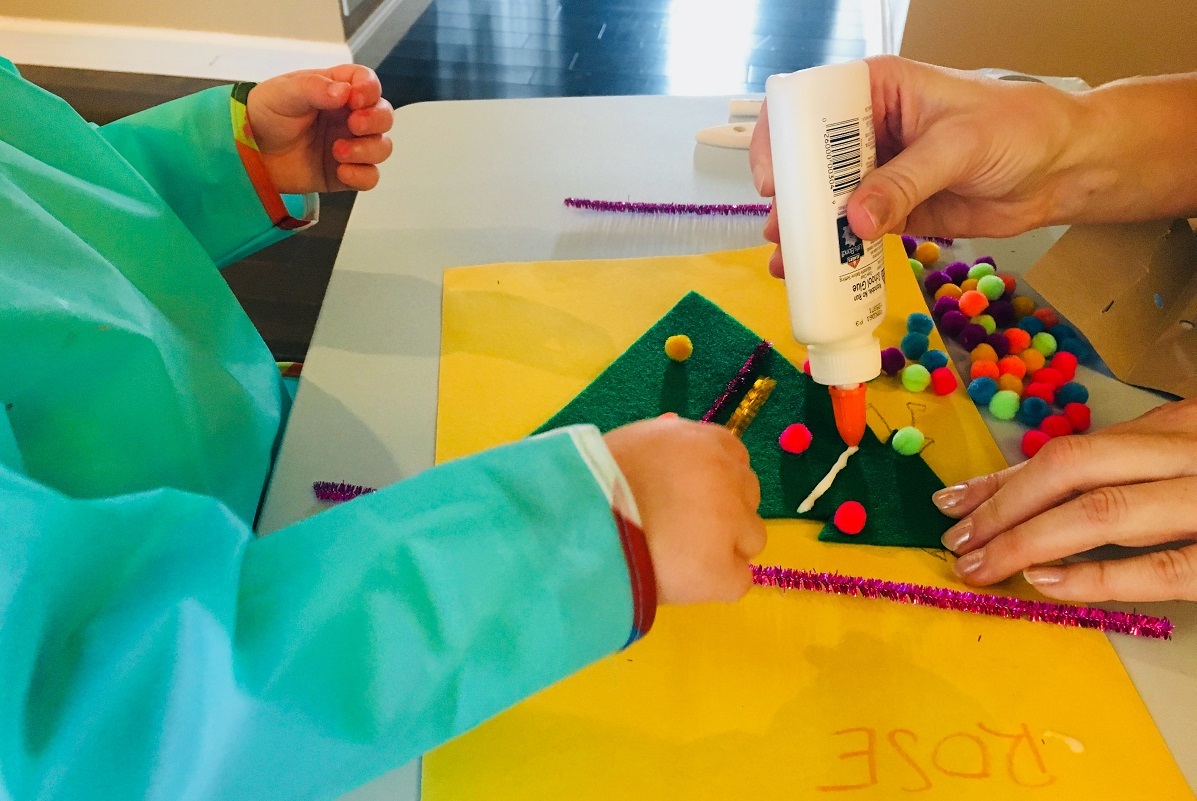 little girl making a felt christmas tree