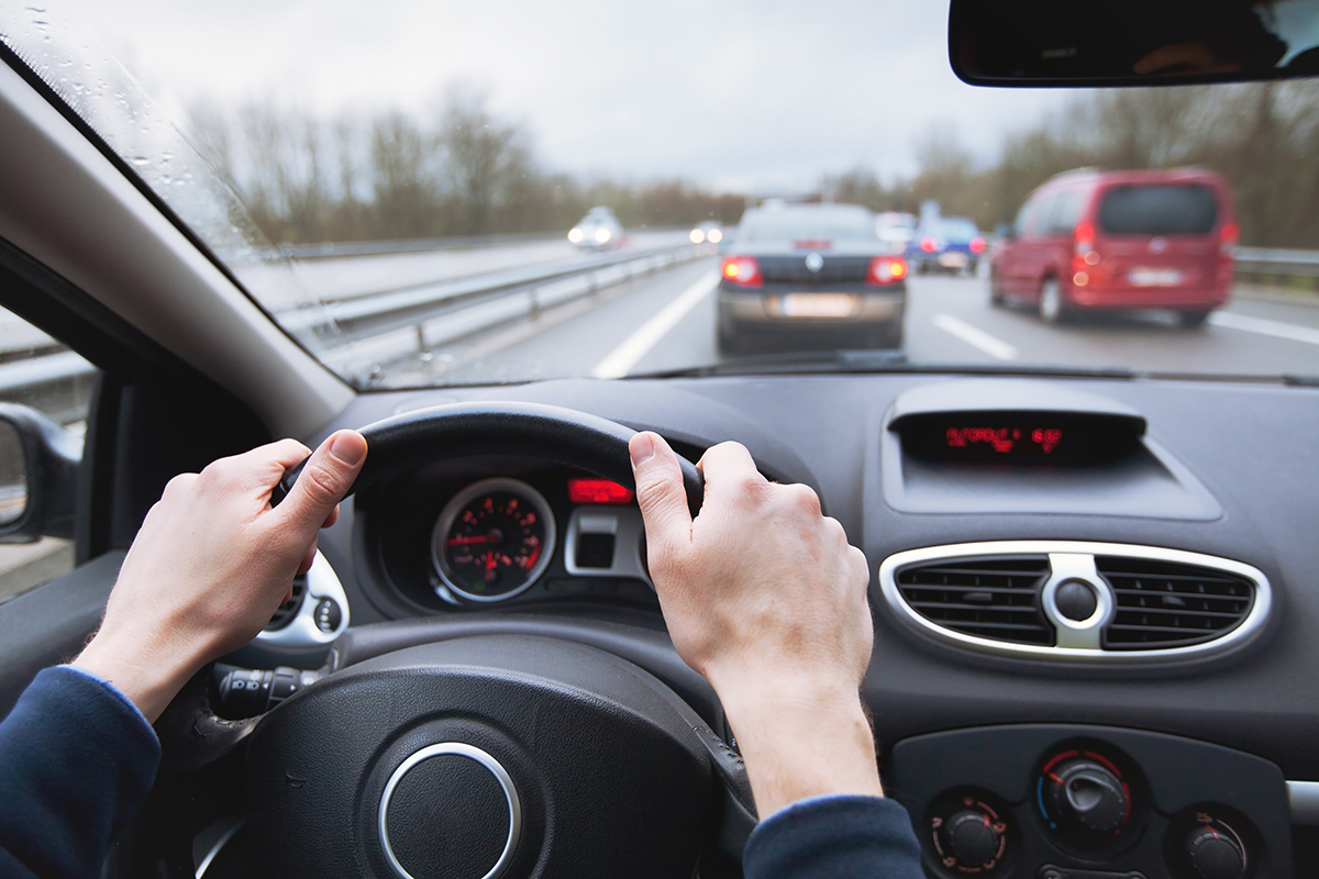 A person drives their car in traffic.